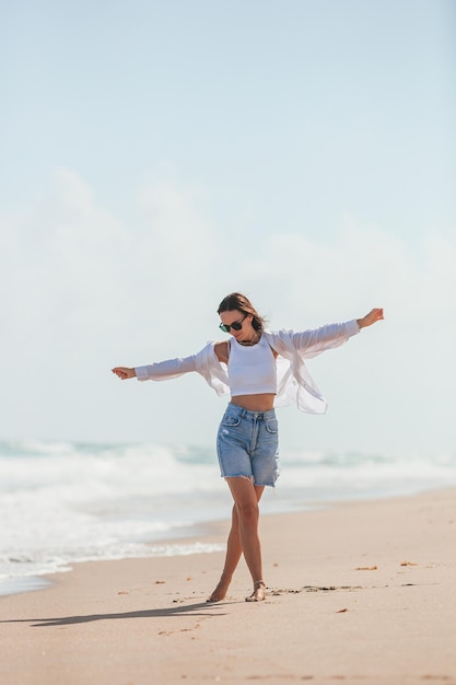 Young happy woman on the beach enjoy her summer vacation Girl is happy and calm in her stay on the beach