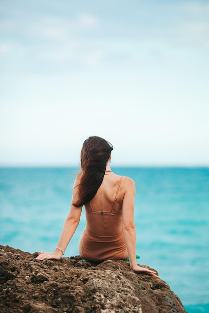 Young happy woman on the beach enjoy her summer vacation