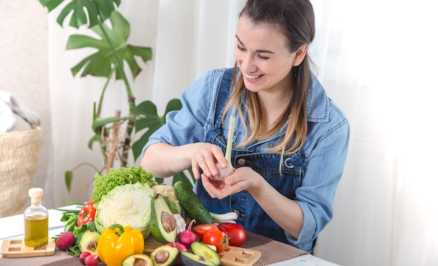 Young and happy woman eating salad at the table