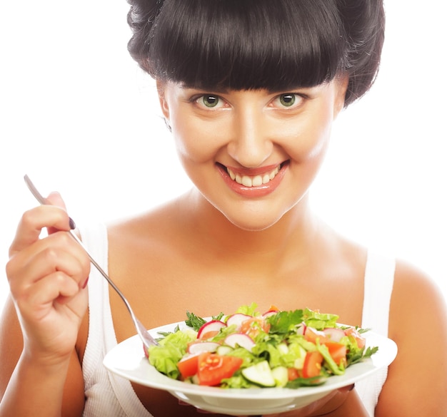 Young happy woman eating salad