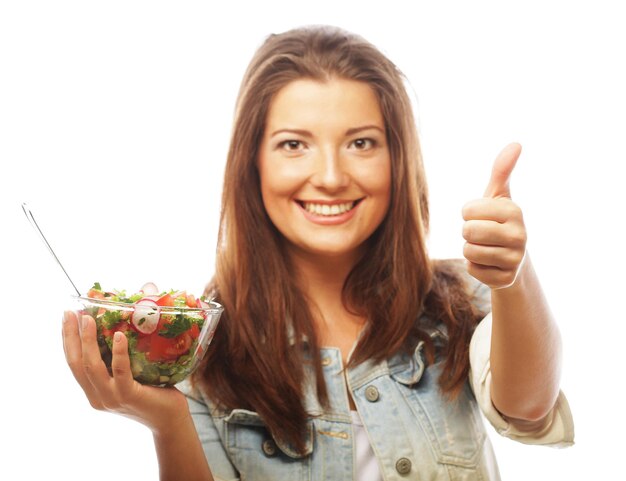 Young happy woman eating salad