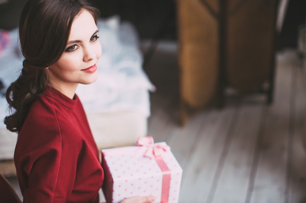 Young happy woman holding a stylish gift.