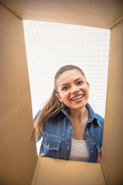 The young happy woman looking in box.