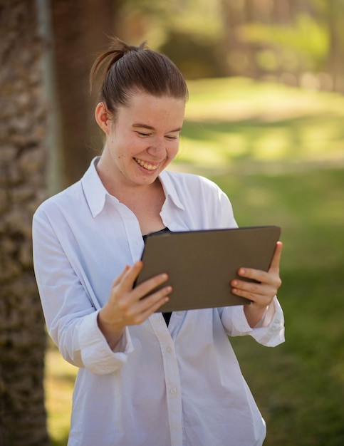 Young happy woman looking for a job using her tablet