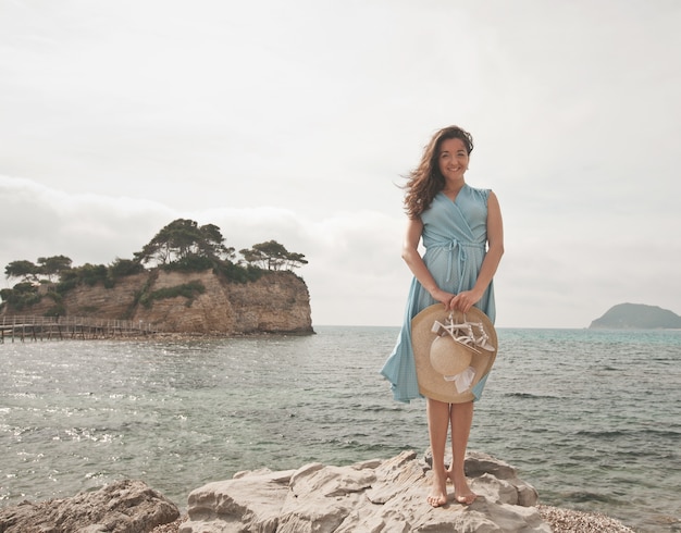 Young happy woman posing near the sea