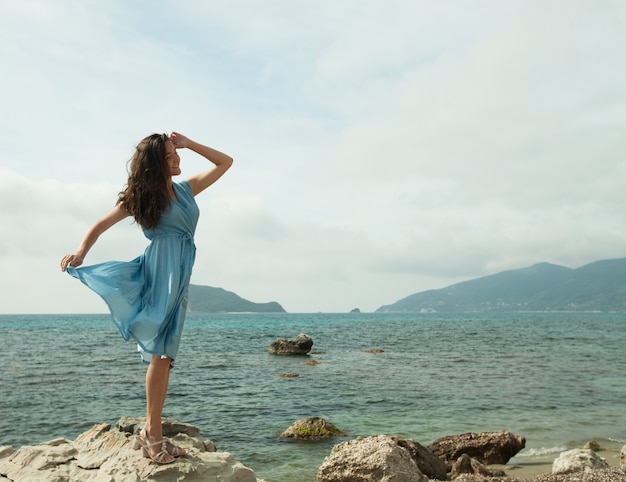 Young happy woman posing near sea