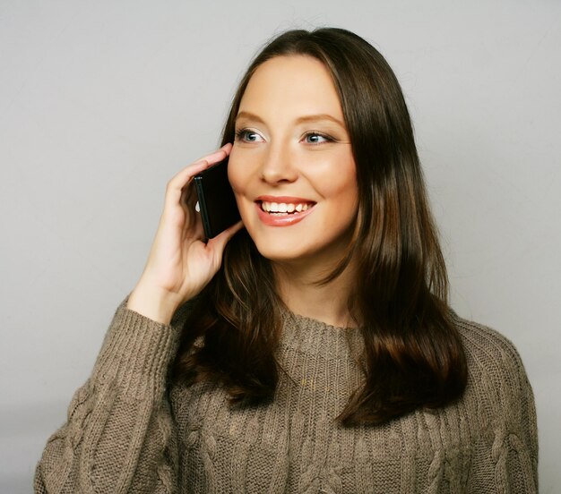 young happy woman using a mobile phone isolated on a white background