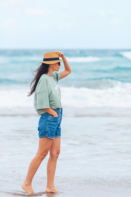 Young happy woman walking on the beach