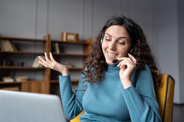 Photo young happy woman wearing handsfree headset with mic consulting client remotely from home office