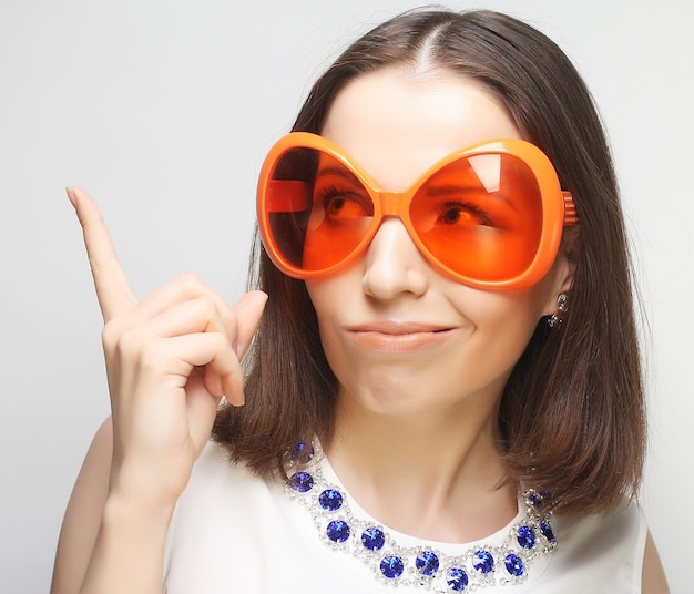 Young happy woman with big orange sunglasses