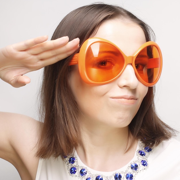 young happy woman with big orange sunglasses