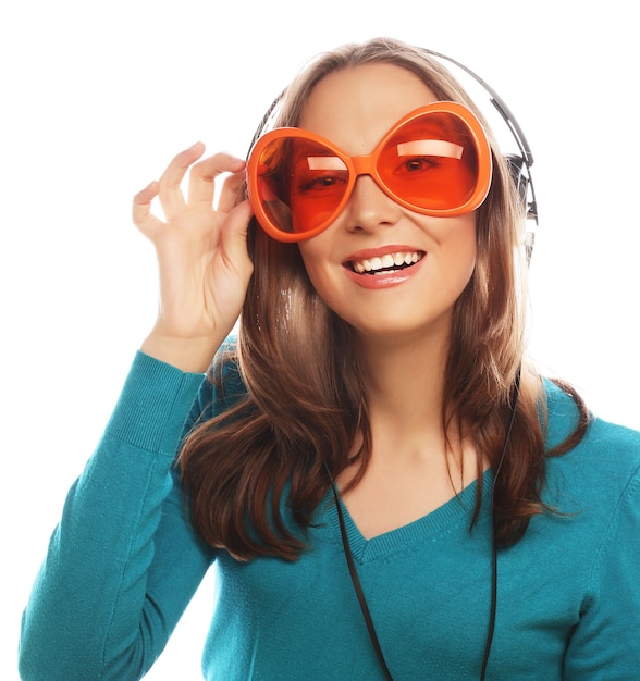 Young happy woman with headphones listening music over white background