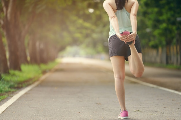 Young Healthy fitness woman runner stretching legs