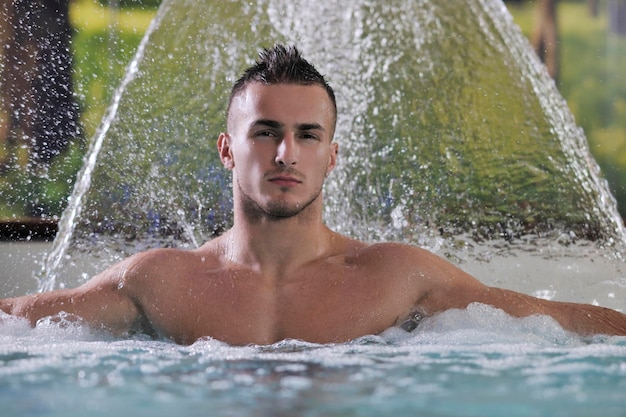 young healthy good looking macho man model athlete at hotel indoor pool