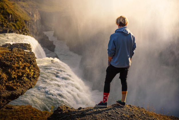 Young hiker standing at the edge of the gullfoss waterfall in iceland