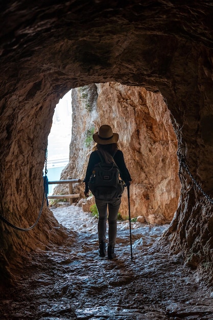 A young hiker in the tunnel of the trail in the Penon de Ifach Natural Park