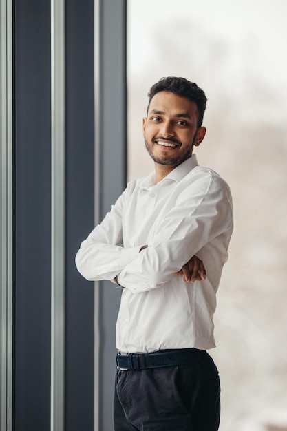 Young Hindu businessman posing near the window in the office