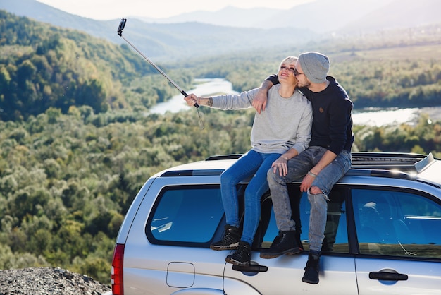 Young hipster couple in love making selfie using smart phone