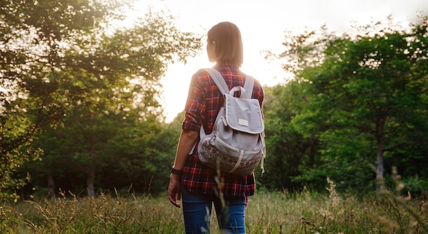 Young hipster girl enjoy sunset Travel woman with backpack