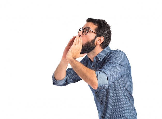 Young hipster man shouting over white background