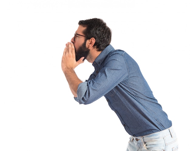 Young hipster man shouting over white background  