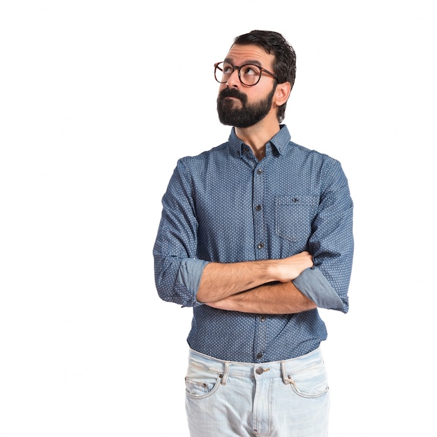 Young hipster man thinking over white background