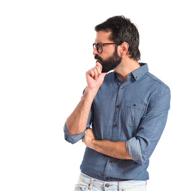 Young hipster man thinking over white background 