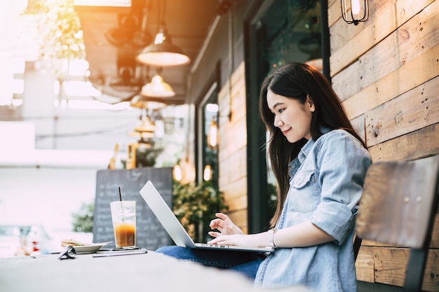 Young hipster woman happy with online social connection on laptop computer