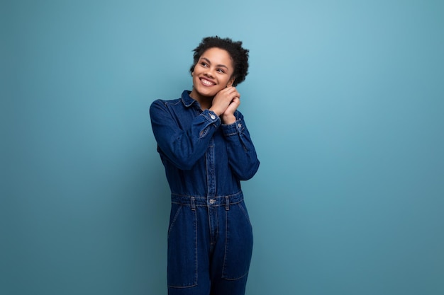 Photo young hispanic brunette woman with fluffy curly hair posing in blue denim suit