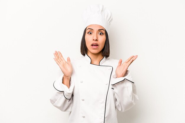 Young hispanic chef woman isolated on white background surprised and shocked