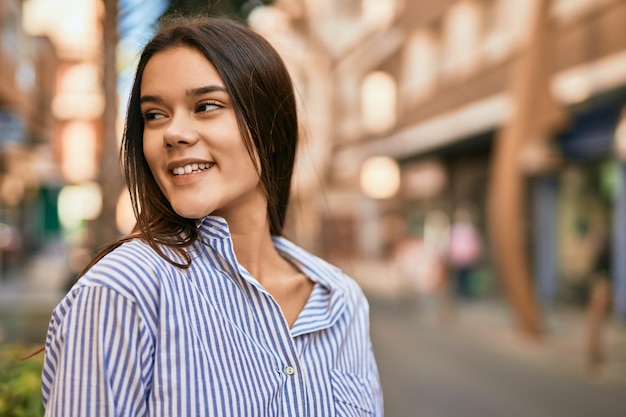 Young hispanic girl smiling happy standing at the city