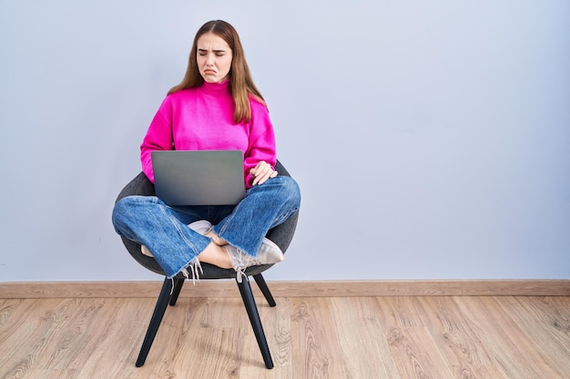 Young hispanic girl working using computer laptop depressed and worry for distress, crying angry and afraid. sad expression.