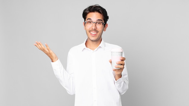 Young hispanic man feeling happy, surprised realizing a solution or idea and holding a take away coffee