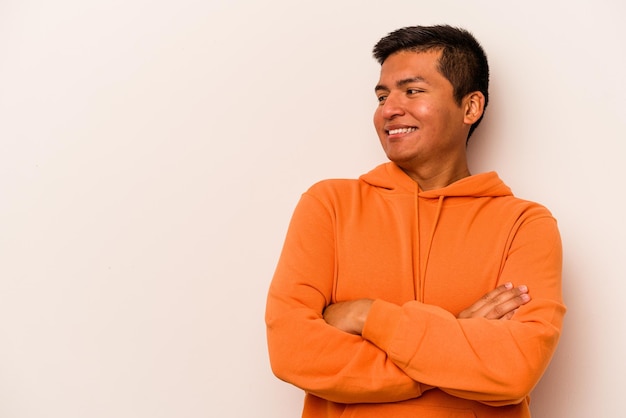 Young hispanic man isolated on white background smiling confident with crossed arms