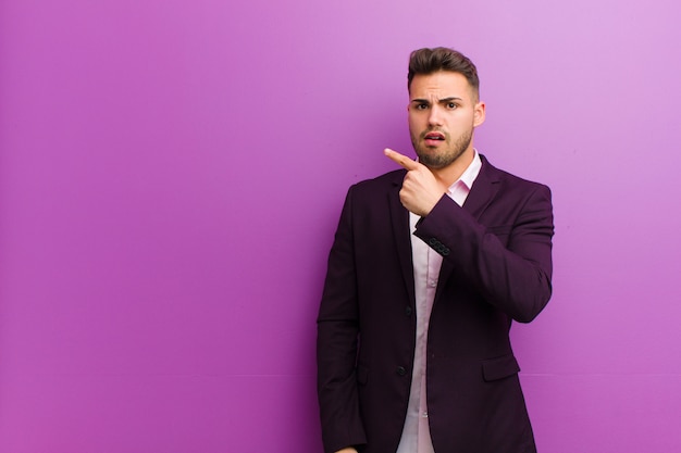 Young hispanic man pointing at camera with an angry aggressive expression