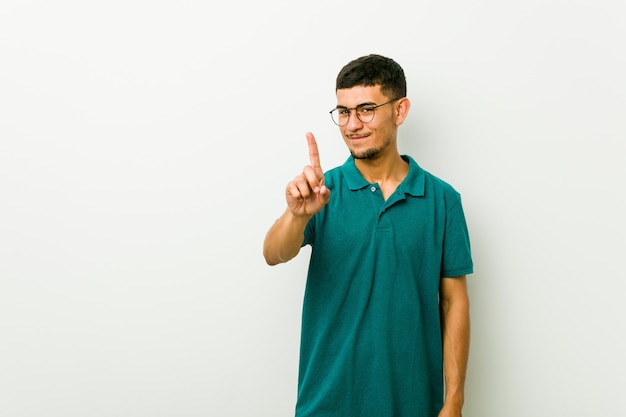 Young hispanic man showing number one with finger.