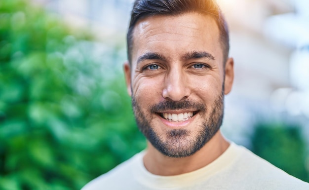 Young hispanic man smiling confident standing at park