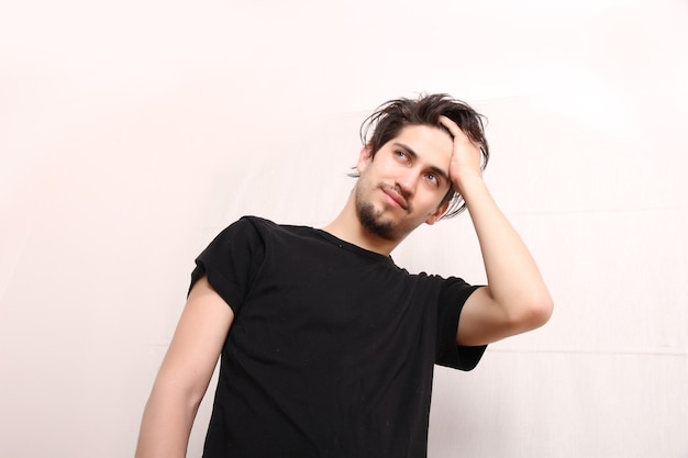 A young hispanic man standing and looking at the camera.