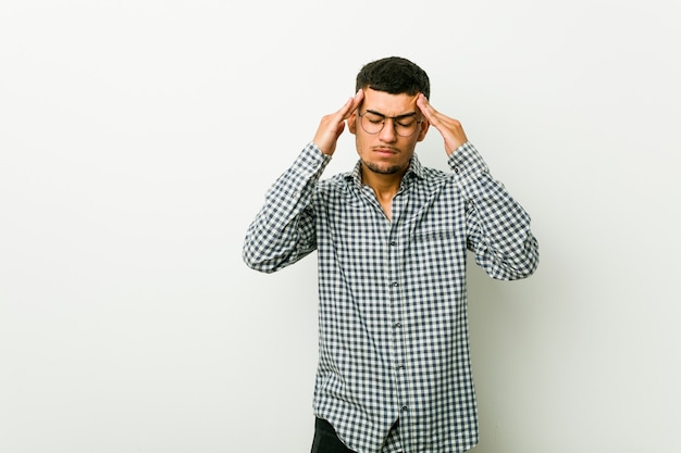 Young hispanic man touching temples and having headache.