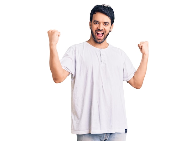 Young hispanic man wearing casual clothes screaming proud celebrating victory and success very excited with raised arms