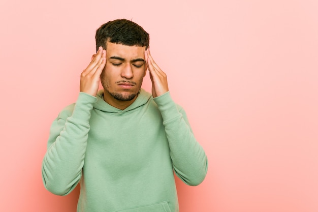 Young hispanic sport man touching temples and having headache.