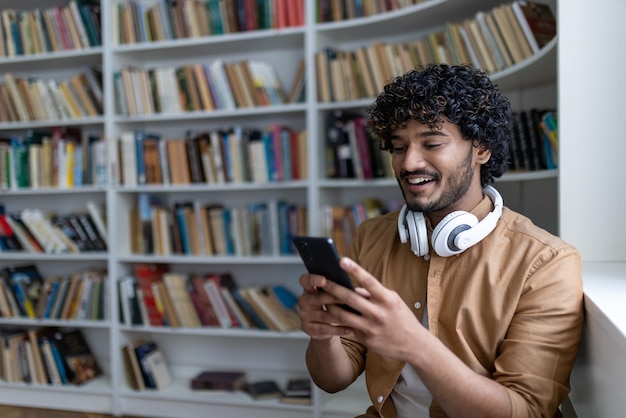 Young hispanic student smiling and happy using online learning app smiling man in headphones sitting