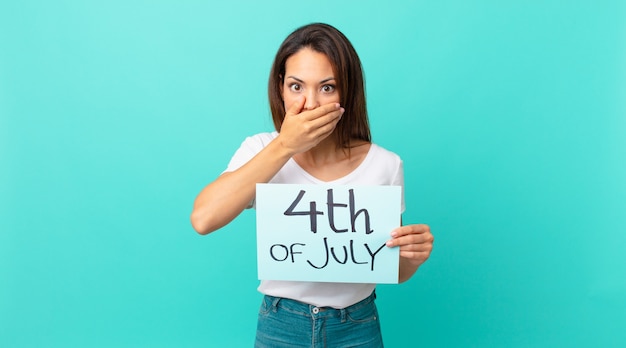 Young hispanic woman covering mouth with hands with a shocked. independence day concept