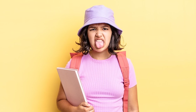 Young hispanic woman feeling disgusted and irritated and tongue out. back to school concept