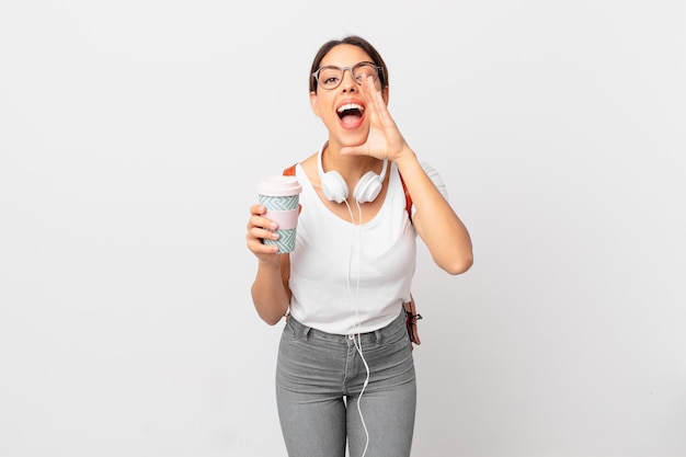 Young hispanic woman feeling happy,giving a big shout out with hands next to mouth. student concept