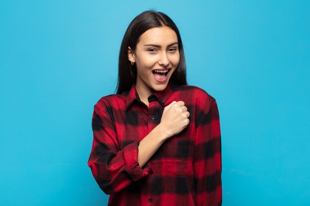 Young hispanic woman feeling happy, positive and successful, motivated when facing a challenge or celebrating good results