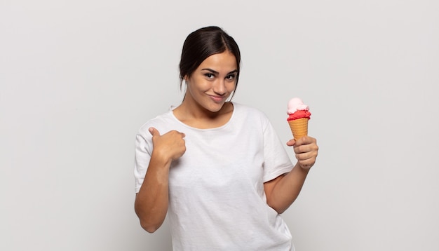 Young hispanic woman feeling happy, surprised and proud, pointing to self with an excited, amazed look