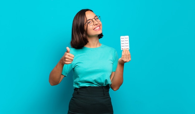 Young hispanic woman feeling proud, carefree, confident and happy, smiling positively with thumbs up