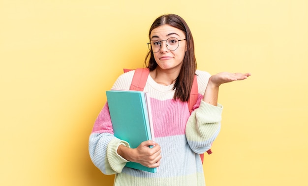 Young hispanic woman feeling puzzled and confused and doubting. student concept