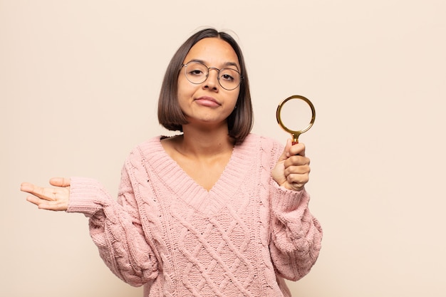 Young hispanic woman feeling puzzled and confused, unsure about the correct answer or decision, trying to make a choice